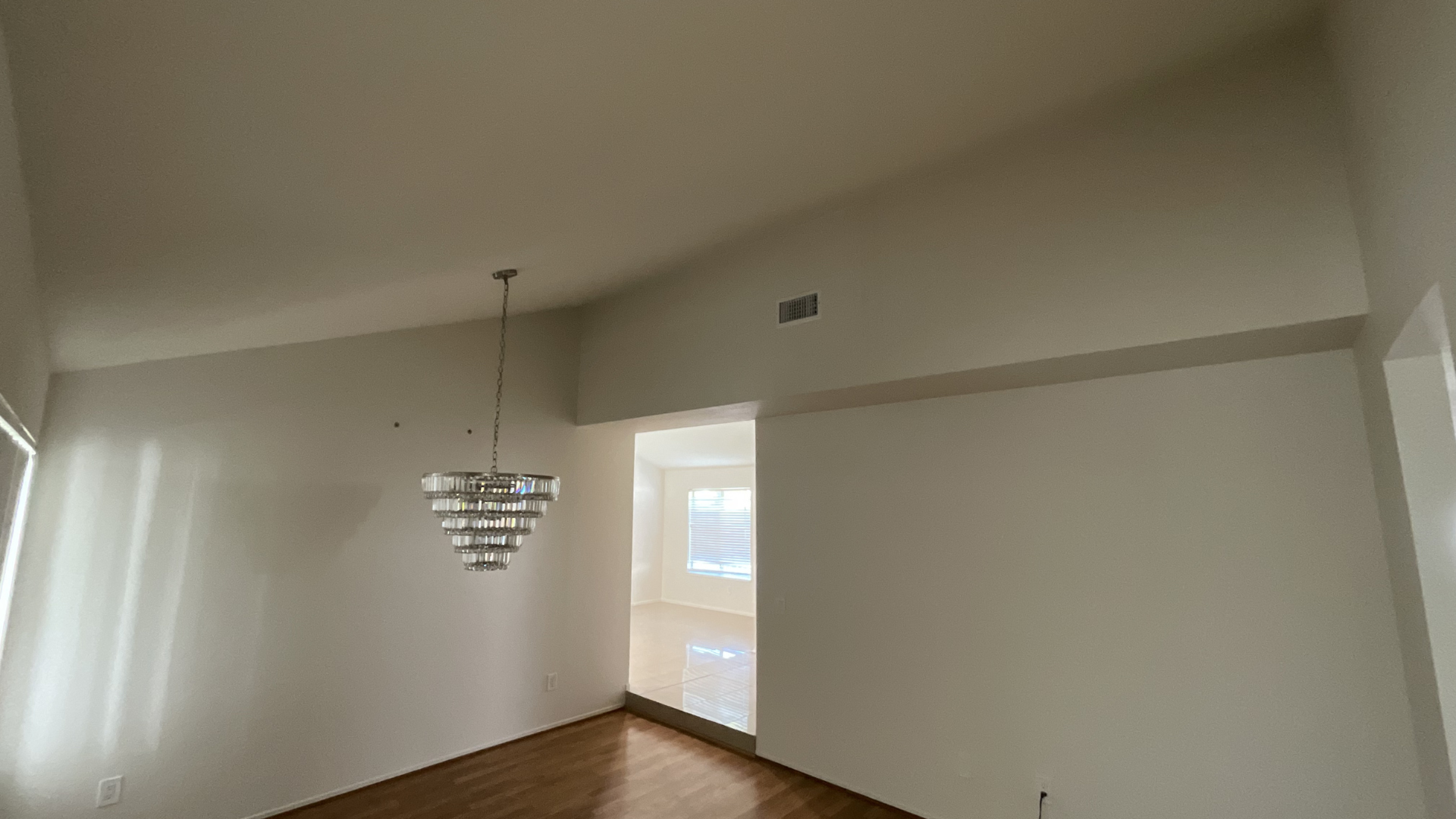 Freshly painted interior living room with vaulted ceiling and chandelier